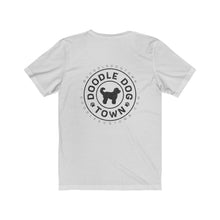 Load image into Gallery viewer, back of white shirt with circle logo with words &quot;Doodle Dog Town&quot; Inside following the circle shape and a silhouette of a doodle dog in the center with @DoodleDogTown above the circle and doodledogtown.com below the circle
