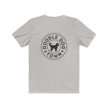Load image into Gallery viewer, back of silver shirt with circle logo with words "Doodle Dog Town" Inside following the circle shape and a silhouette of a doodle dog in the center with @DoodleDogTown above the circle and doodledogtown.com below the circle