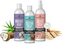 Load image into Gallery viewer, Collection of three bottles from Doodle Dog Town&#39;s grooming product line surrounded by natural ingredients. On the left is an open coconut and aloe leaves, then a purple bottle of Bright Pup Whitening Dog Wash Shampoo, next is the Clean Pup 5-in-1 Dog Wash Shampoo, then the Silky Pup Detangler Spray, on the right is oatmeal in a wooden spoon. There is also an icon that reads Naturally Derived Ingredients
