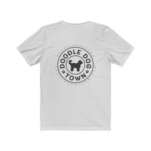 Load image into Gallery viewer, back of white shirt with circle logo with words &quot;Doodle Dog Town&quot; Inside following the circle shape and a silhouette of a doodle dog in the center with @DoodleDogTown above the circle and doodledogtown.com below the circle
