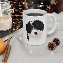 Load image into Gallery viewer, black, white and brown bernedoodle illustration on white mug with steaming coffee on table with holiday decorations
