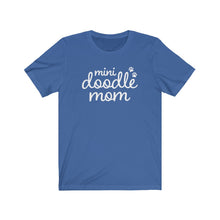 Load image into Gallery viewer, White script cute text that reads &quot;mini doodle mom &quot;with two paws on the right side on a royal blue T-shirt

