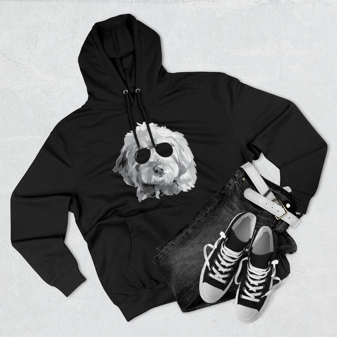 black hoodie sweatshirt lying flat with black and white illustration of goldendoodle dog with black sunglasses. a pair of black jeans and bland and white shoes are lying next to the sweatshirt