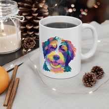 Load image into Gallery viewer, Colorful pop art illustration of doodle dog, perhaps a Bernedoodle or Goldendoodle on white ceramic mug with handle on right and coffee steaming from the cup and 2 across and cinnamon stickers with lit candle and string of fairy lights in an overall holiday themed scene
