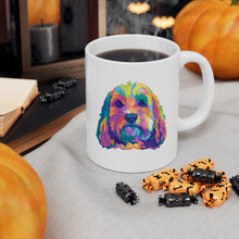 Load image into Gallery viewer, colorful Cockapoo dog pop art illustration on ceramic mug with steaming coffee and Halloween candy in front with pumpkins and black candles behind it
